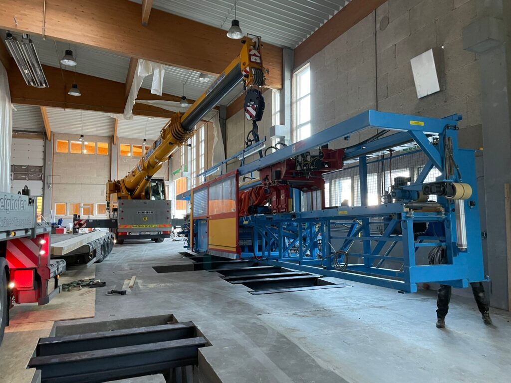 Unsere Abbundanlage wird mit Kran und LKW in die neue Zimmerei-Halle gebracht